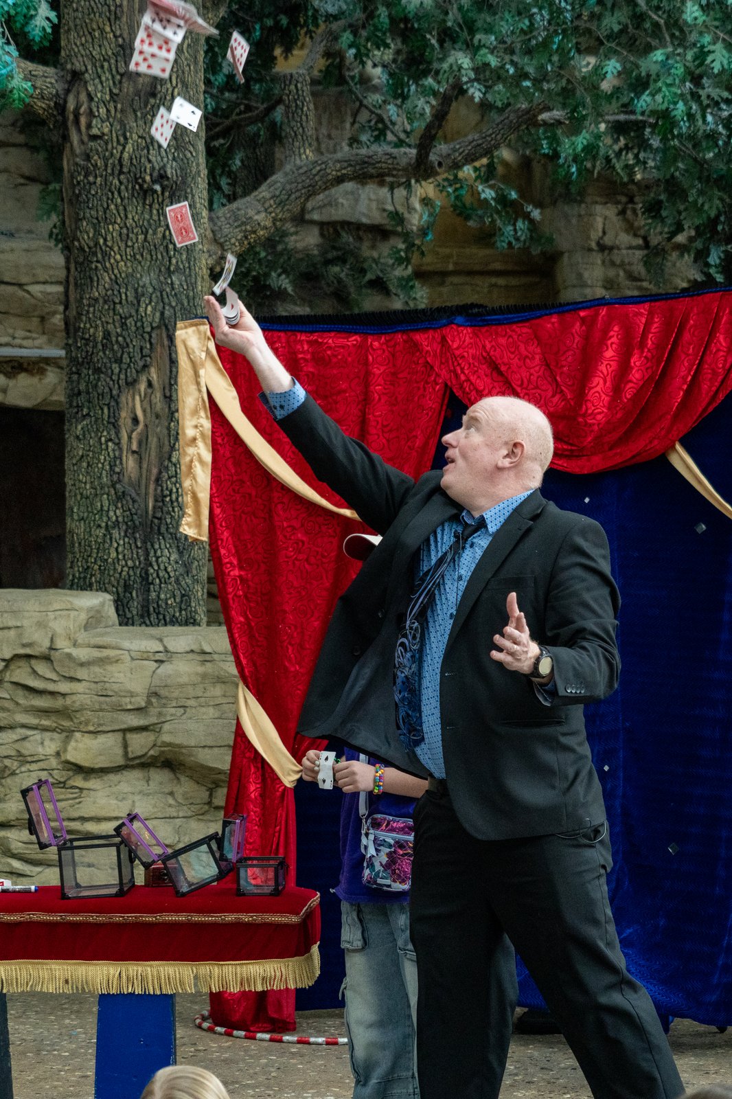 Scott Henderson tossing a deck of cards into the air on stage