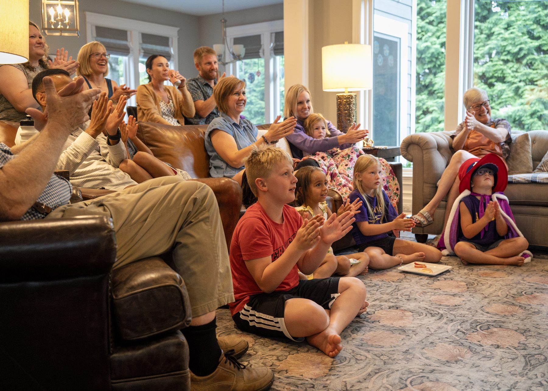 A multi-generational living room, every hand mid-clap.