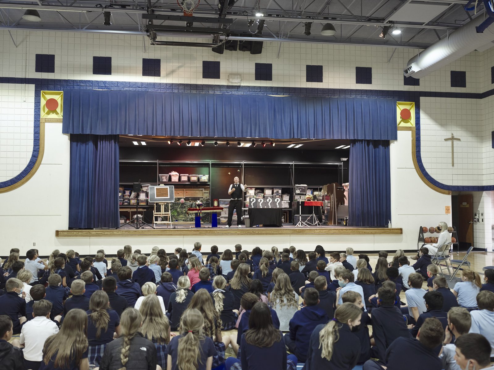 Stage lights up, the gym goes quiet.